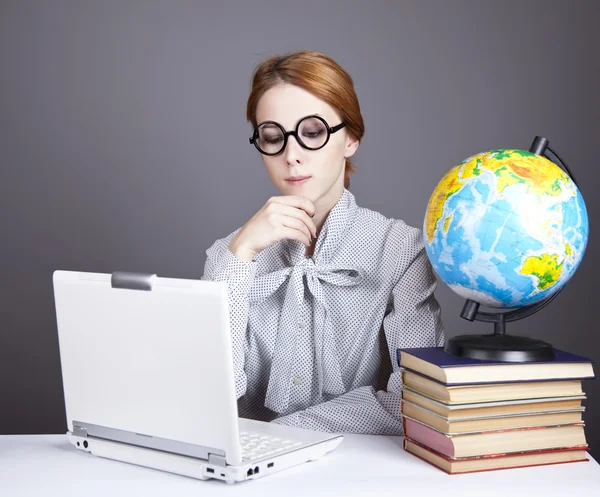 The young teacher in glasses with books, globe and notebook. — Stock Photo, Image