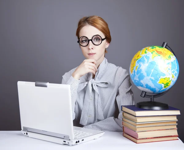 A fiatal tanár, szemüveg, könyvekkel, a globe és a notebook. — Stock Fotó