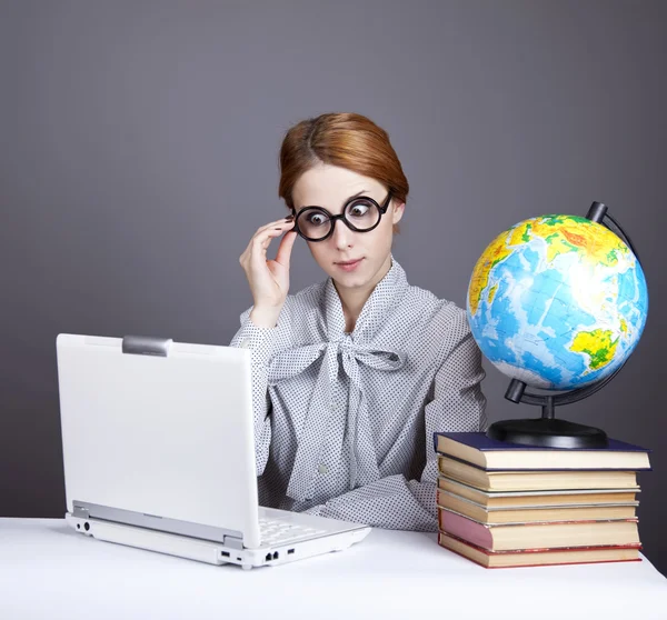 The young teacher in glasses with books, globe and notebook. — Stock Photo, Image