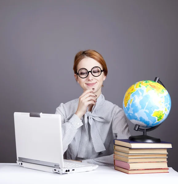 A fiatal tanár, szemüveg, könyvekkel, a globe és a notebook. — Stock Fotó