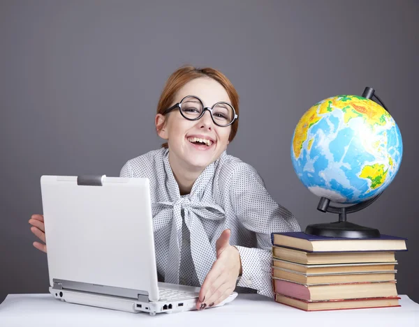 Mladý učitel v brýlích s knihami, glóbus a notebook. — Stock fotografie