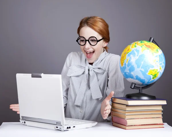 Der junge Lehrer in Brille mit Büchern, Globus und Notizbuch. — Stockfoto