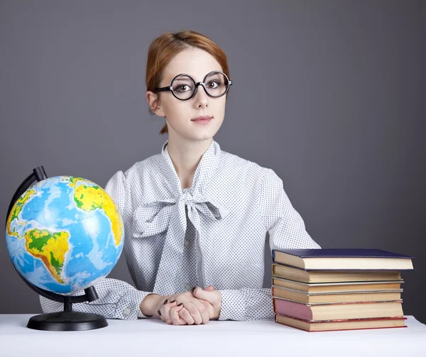 Молодой учитель в очках с книгами и глобусом . — стоковое фото
