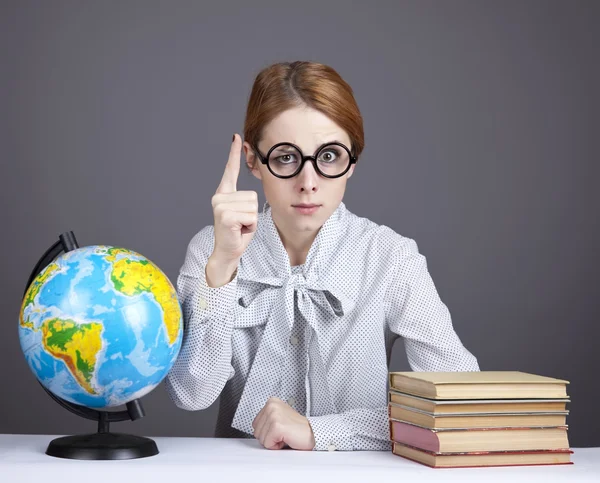 Mladý učitel v brýlích s knihami a zeměkoule. — Stock fotografie