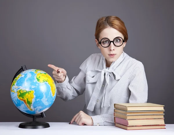 De jonge leraar in glazen met boeken en globe. — Stockfoto