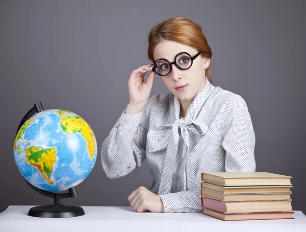 Mladý učitel v brýlích s knihami a zeměkoule. — Stock fotografie
