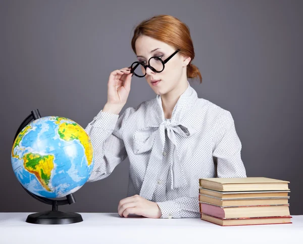 De jonge leraar in glazen met boeken en globe. — Stockfoto