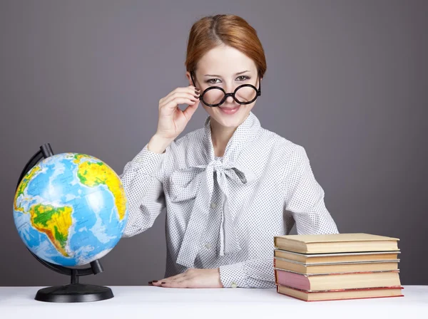 Guru muda berkacamata dengan buku dan bola dunia . — Stok Foto