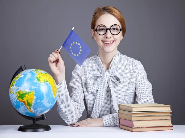 The young teacher in glasses with books and globe. — Stock Photo, Image