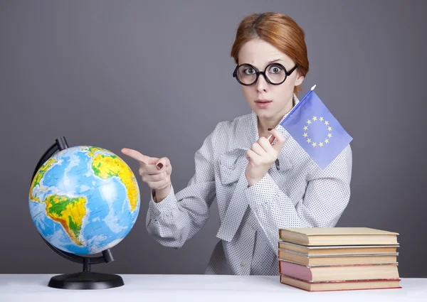 Den unga läraren i glas med böcker och globe. — Stockfoto