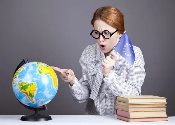 Der junge Lehrer in Brille mit Büchern und Globus. — Stockfoto