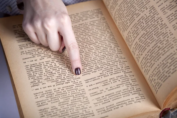 stock image Women finger pointing on the book page.