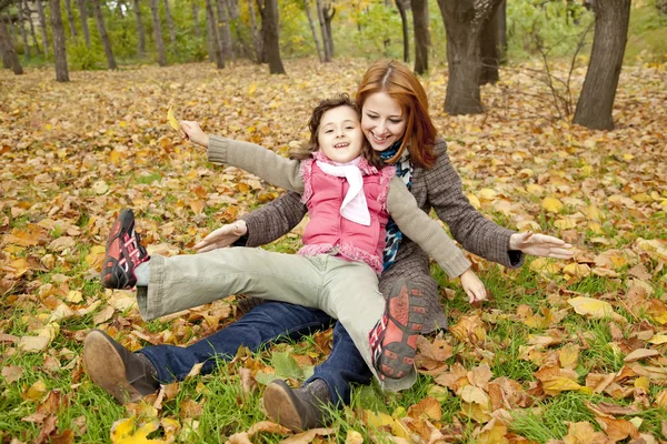 Oturan iki kız kardeş parkta yapraklar. — Stok fotoğraf