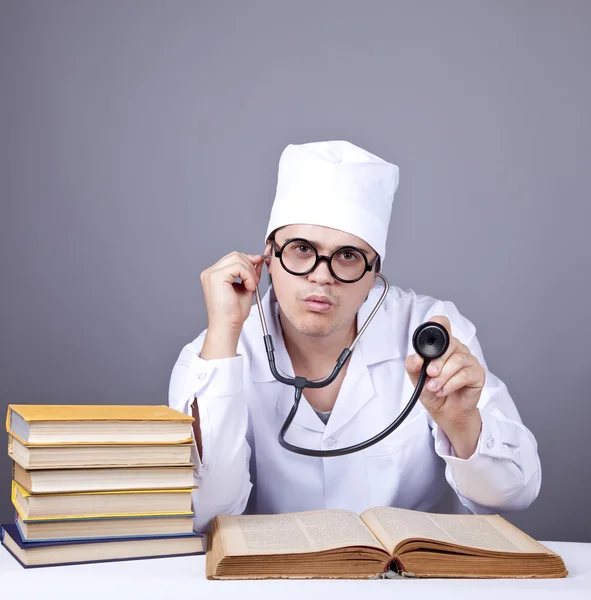 Young doctor with books and computer. — Stock Photo, Image