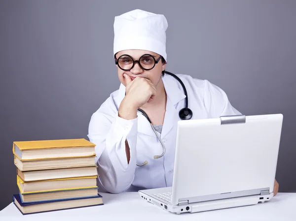 Young doctor with books and computer. — Stock Photo, Image