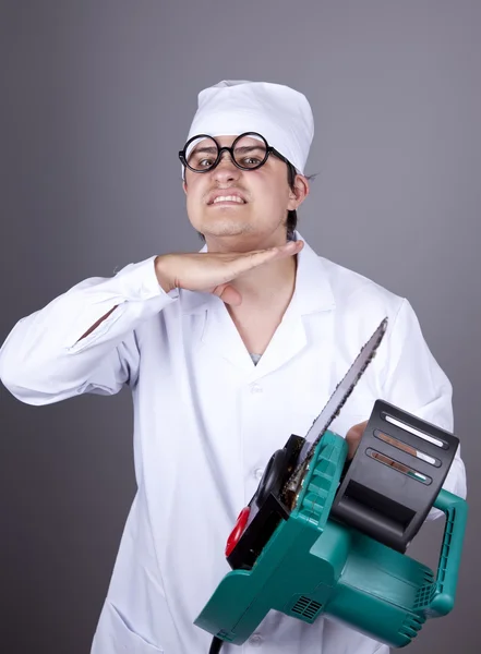 Crazy doctor with portable saw. Stock Photo