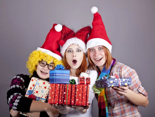 Three girlfriends in funny hats with christmas gifts. — Stock Photo, Image