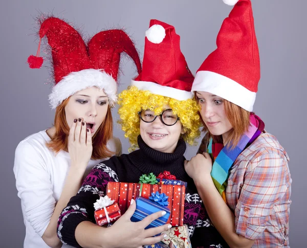 Three girlfriends in funny hats with christmas gifts. — Stock Photo, Image