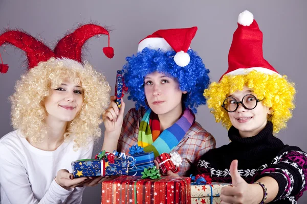 Τρεις φίλες σε αστεία καπέλα με τα δώρα Χριστουγέννων. — Φωτογραφία Αρχείου