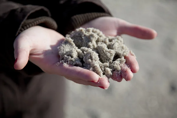 Våt sand i kvinnor händer. — Stockfoto