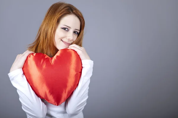 Vacker rödhårig flicka med leksak hjärta. — Stockfoto
