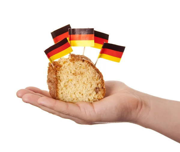 Ręka trzymać ciasto z flag Niemiec. — Zdjęcie stockowe