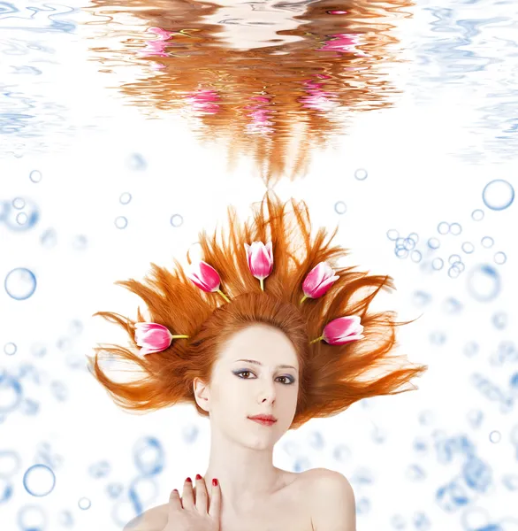Beatiful red-haired girl with tulips in hair underwater. — Stock Photo, Image