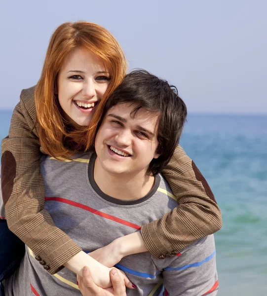 Retrato de um jovem casal feliz se divertindo na praia . — Fotografia de Stock