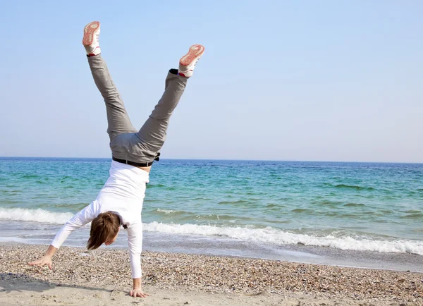 Ung kille dansar en paus-dans på en strand — Stockfoto