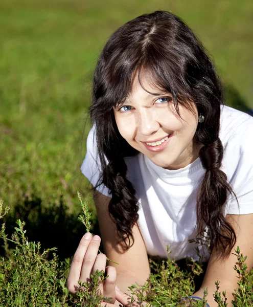 Retrato de bela menina morena com olhos azuis em gras verdes — Fotografia de Stock