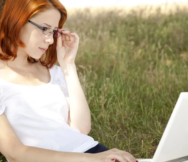 Jonge mode meisje in glazen en laptop zitten in de buurt van — Stockfoto