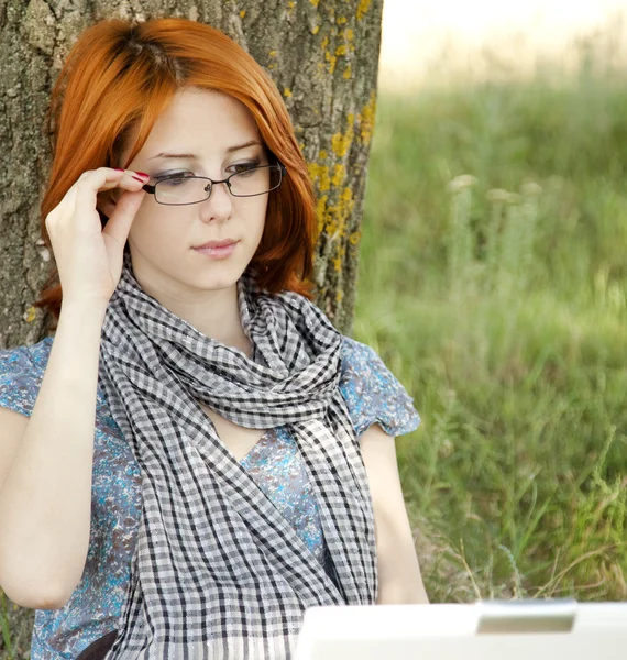 Mladý usmívající se móda dívka v brýle a notebook poblíž — Stock fotografie