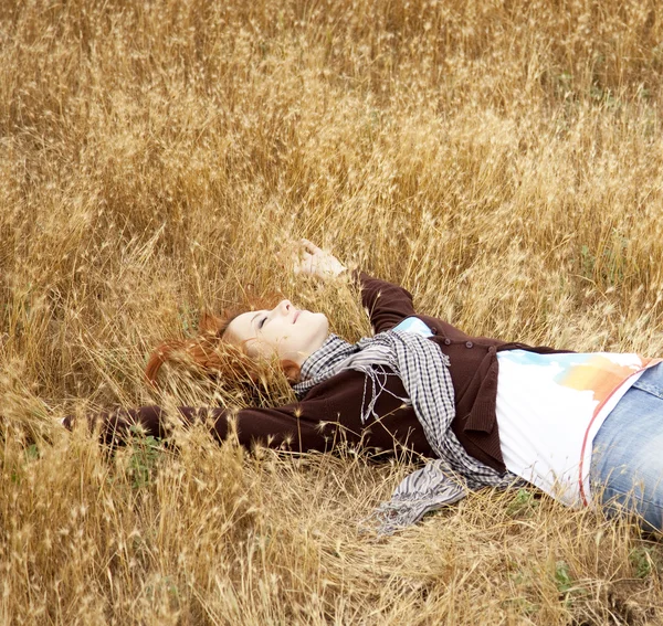 Ung vacker flicka liggande på gula höst field. — Stockfoto