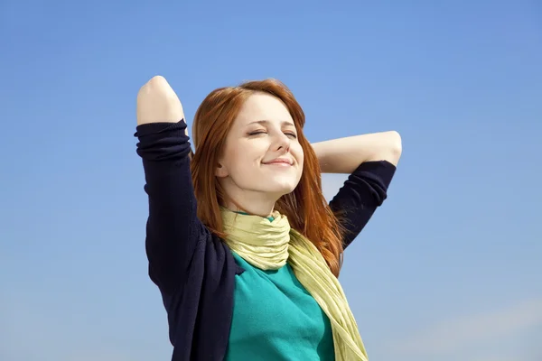 Portrait of red-haired girl on blue sky background. — Stock Photo, Image