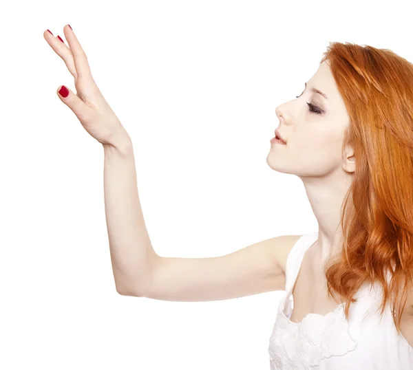 Red-haired girl tuching something in the air. — Stock Photo, Image