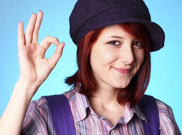 Beautiful girl in shirt and violet cap show OK — Stock Photo, Image