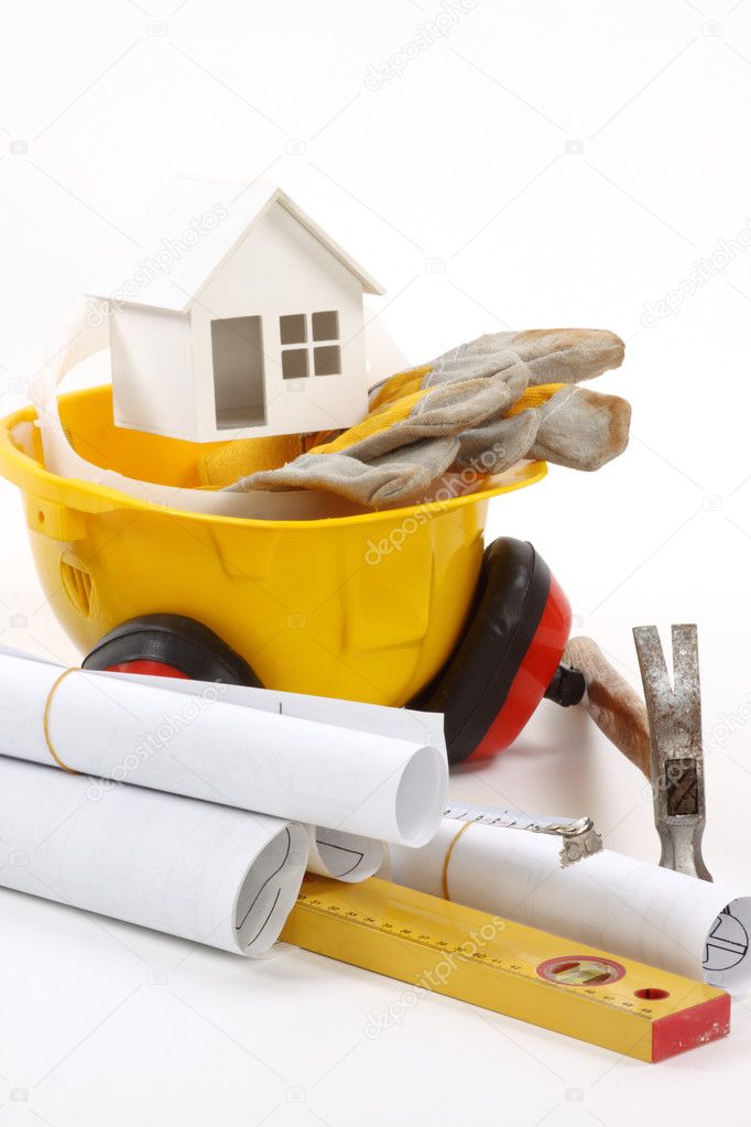 Construction concept- house model, industrial tools and protective gear