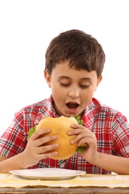 bir büyük hamburger yiyen çocuk