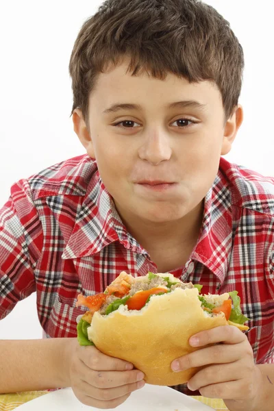 Pojke som äter en stor hamburgare — Stockfoto