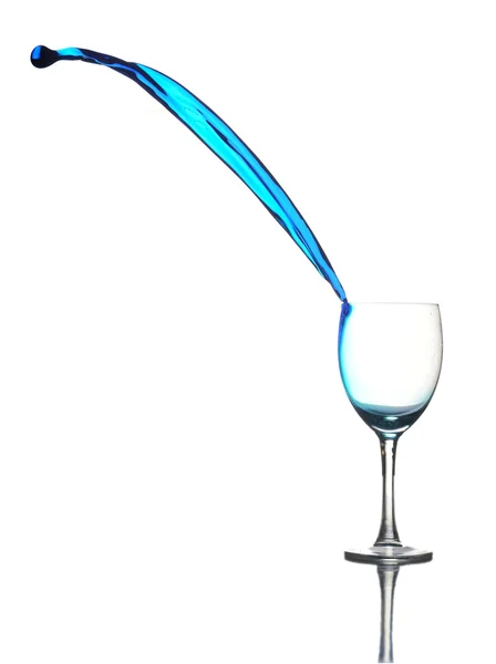 stock image Colored liquid splashing out a glass