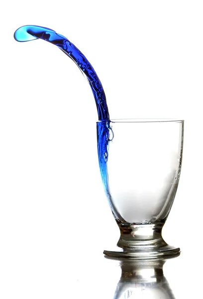 Líquido colorido salpicando para fora um copo — Fotografia de Stock