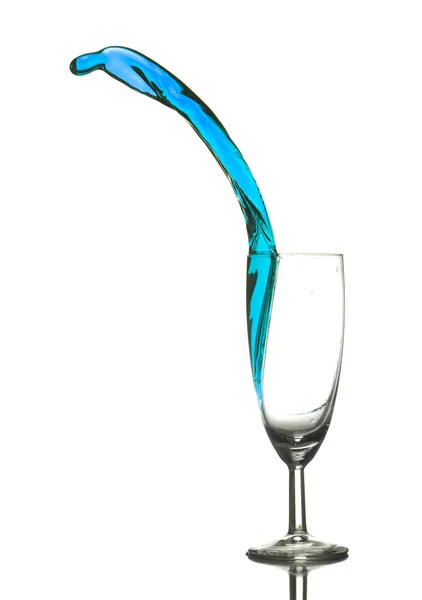 Цветная жидкость выплескивает стакан — стоковое фото