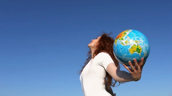 Vrouw met globe onder hemel — Stockfoto