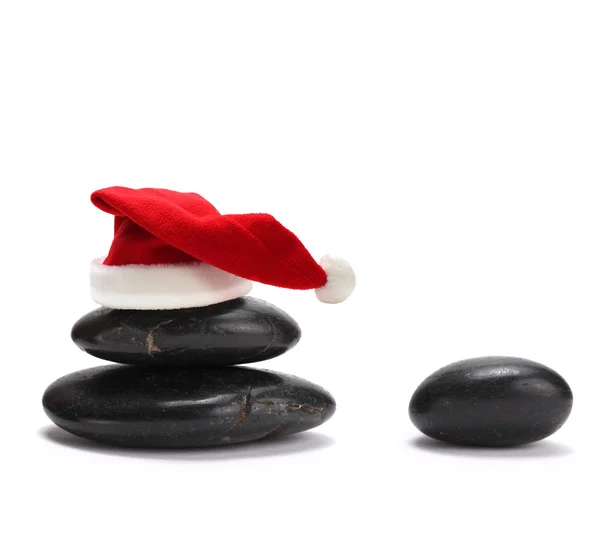 Stack av stenar med röd jultomten hatt — Stock fotografie
