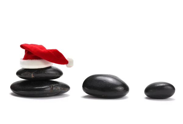 Red santa claus hat and stones — Stock Photo, Image