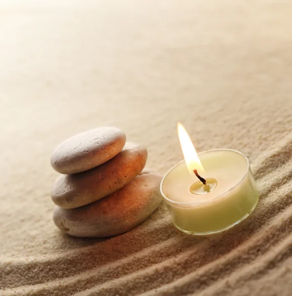 Stack of pebbles and light candle — Stock Photo, Image