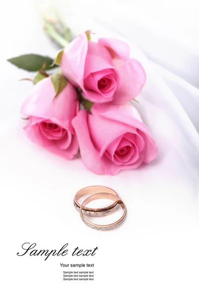 Wedding rings and pink roses — Stock Photo, Image