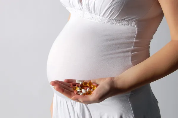 Zwangere vrouw bedrijf tabletten Rechtenvrije Stockafbeeldingen