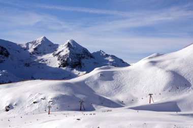 Ski slope with skiing and snowboarding in touristic resort Obertauern in Austrian Alps mountain range in Austria