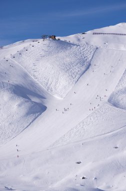 Ski slope with skiing and snowboarding in touristic resort Obertauern in Austrian Alps mountain range in Austria